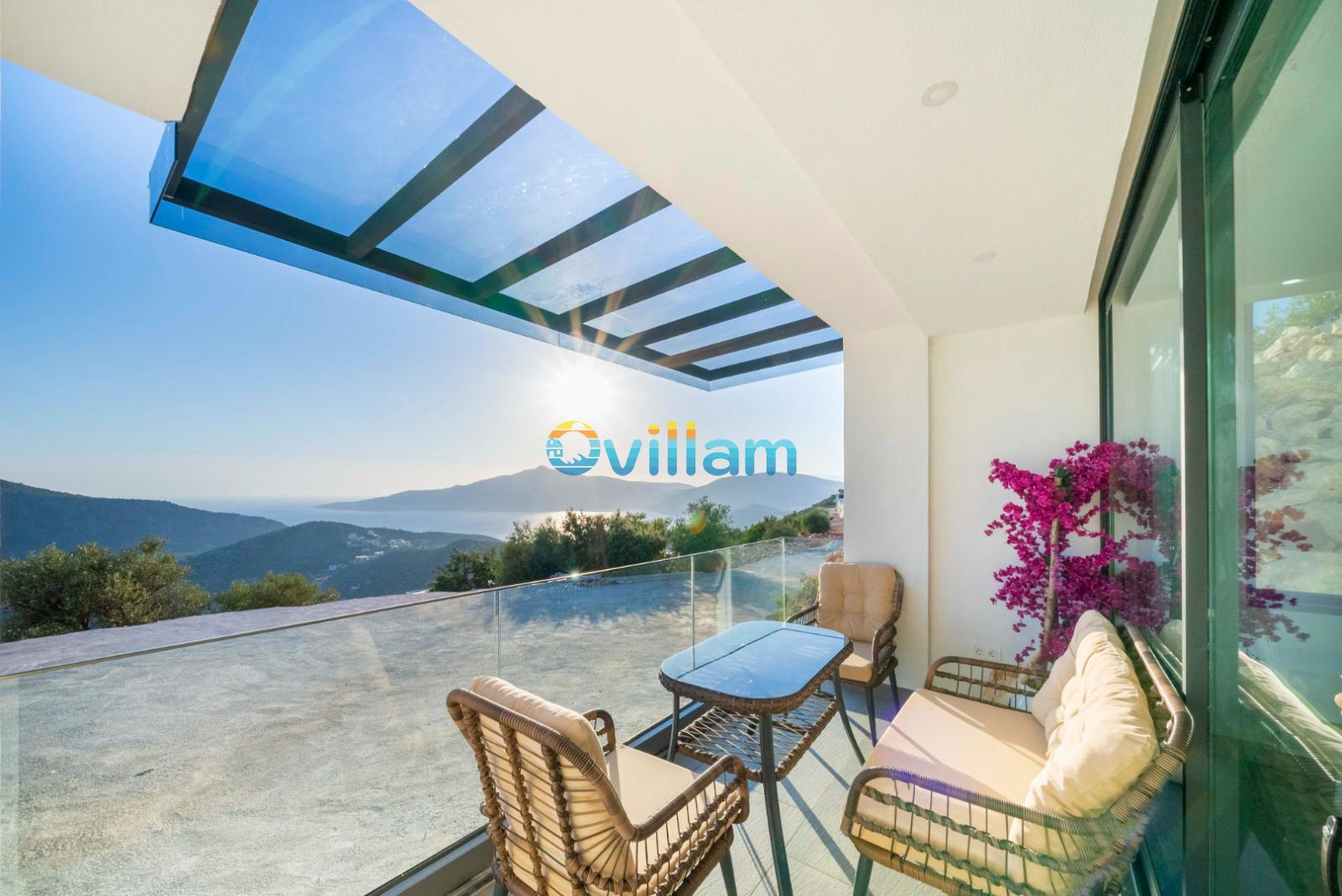 Cam tavanlı ve deniz manzaralı oturma grubu bulunan balkon