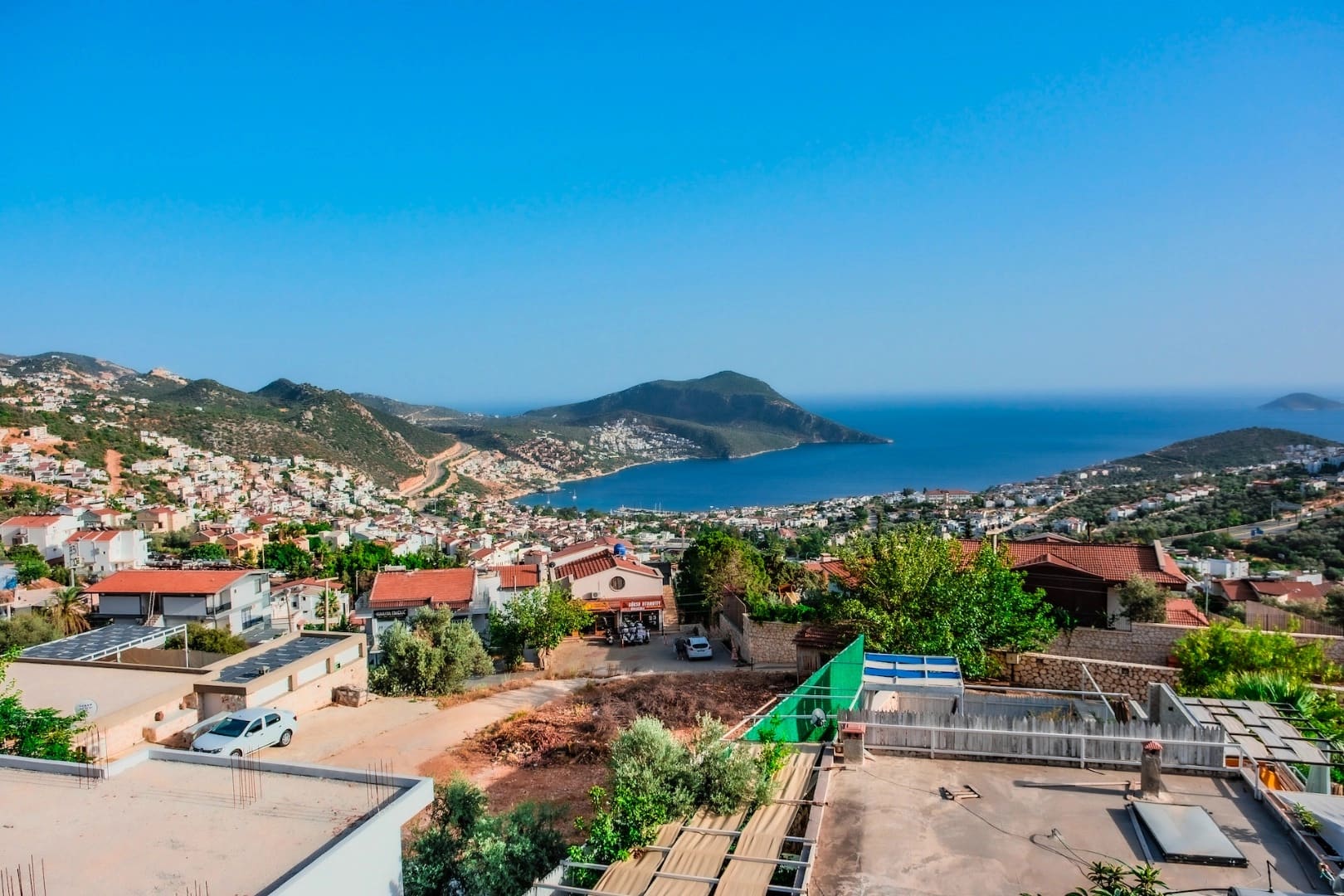 Yüksek bir noktadan görünen deniz, koy ve yerleşim yeri manzarası.