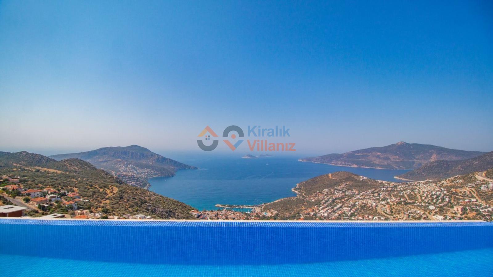 Sonsuzluk havuzunun önünde uzanan Kalkan koyu ve deniz manzarası.
