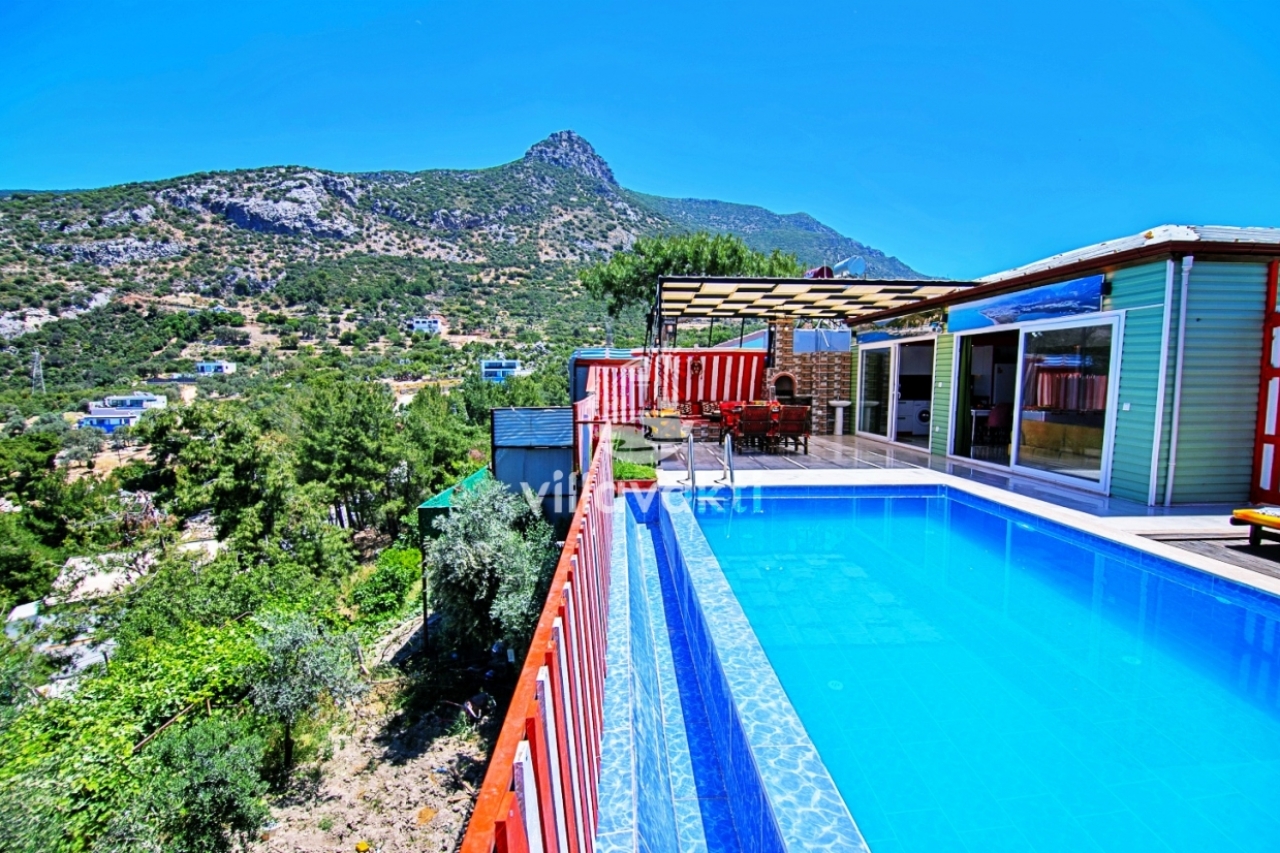 Dağ ve yeşillik manzaralı terasta havuz bulunan villa dış mekanı.