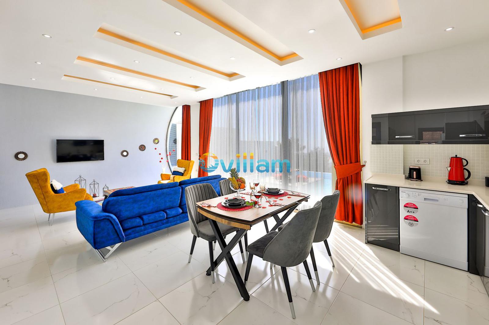 Modern salon ve yemek masası, mavi koltuk ve açık mutfak alanı.