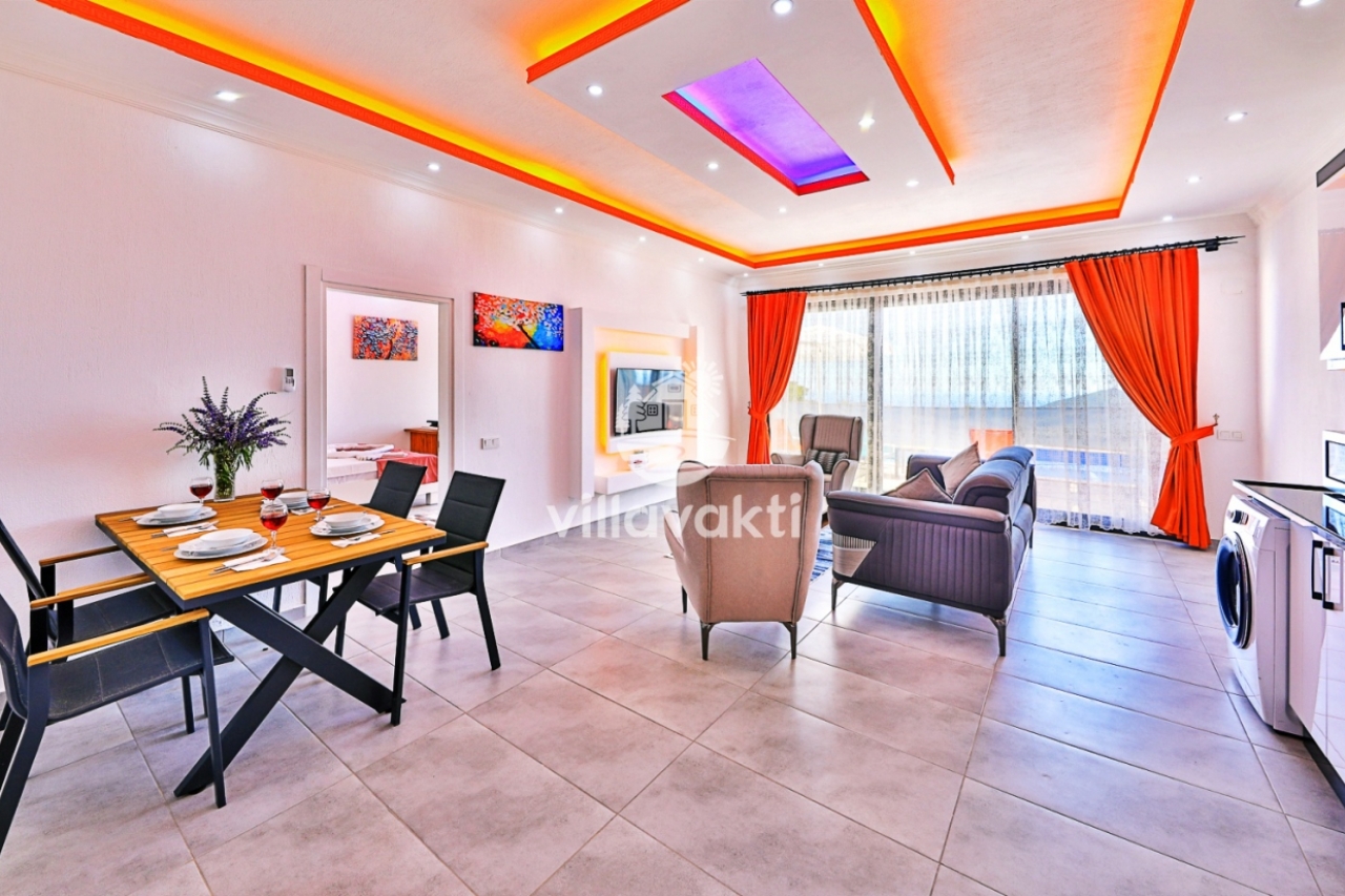 Modern mobilyalı, turuncu perdeli, yemek masası ve oturma grubu içeren salon.