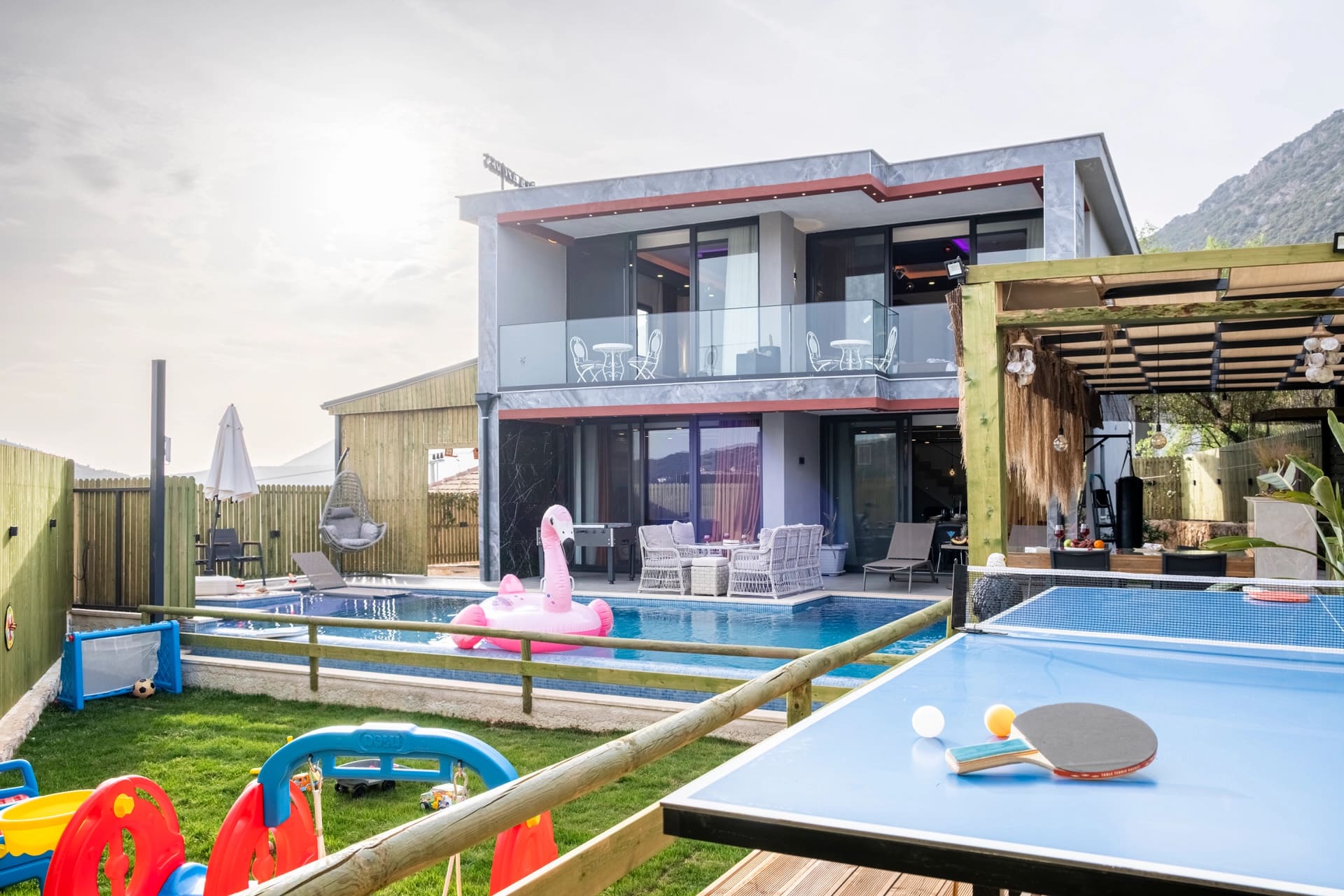 Bahçesinde havuz ve masa tenisi olan modern villa.