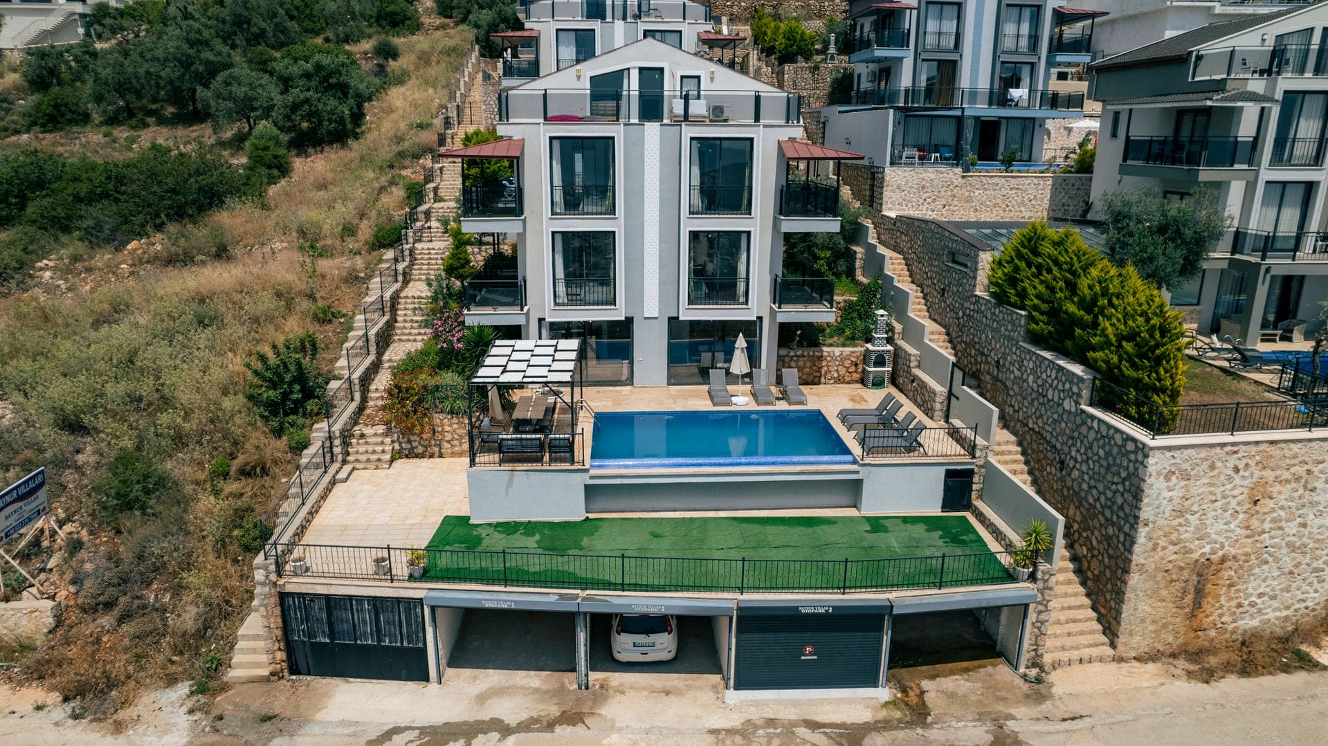 Havuzlu, teraslı ve kapalı otoparkı olan çok katlı modern villa binası.