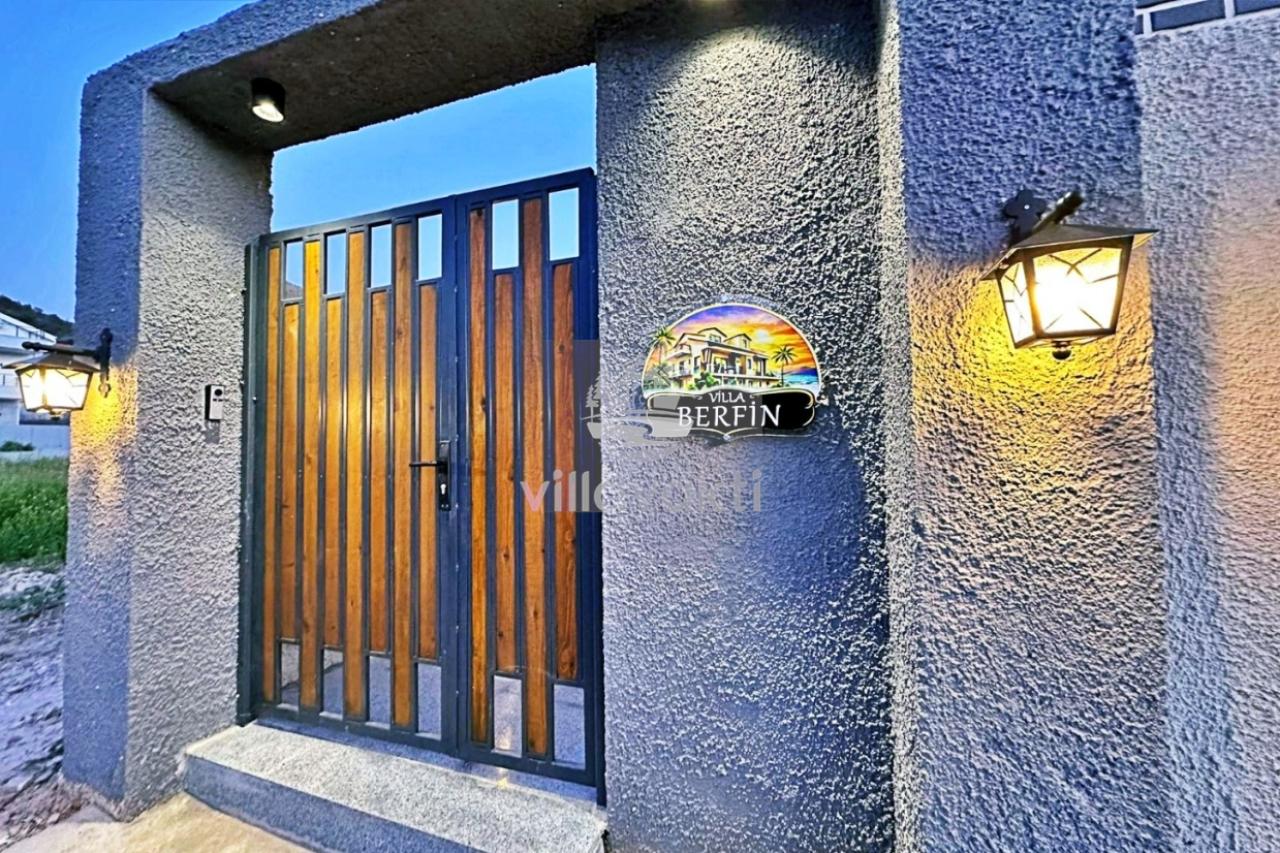 Villa Berfin tabelasının asılı olduğu gri duvarlı giriş kapısı.
