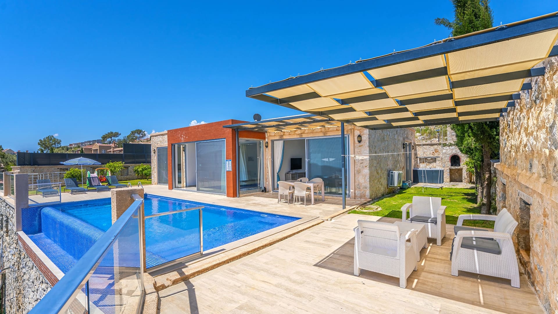 Güneş tenteli terası ve yüzme havuzu bulunan taş villa