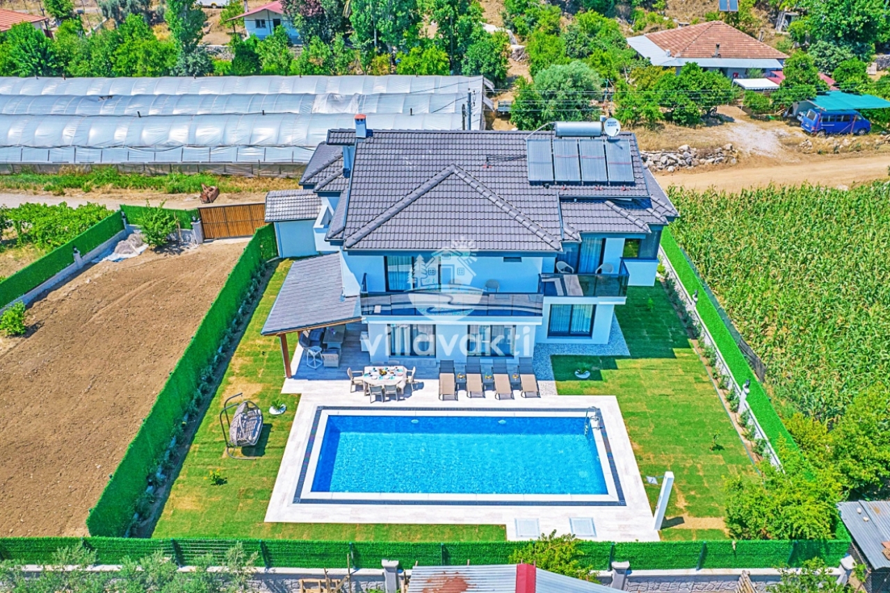 Havuzlu villa ve bahçesinin havadan görünümü.