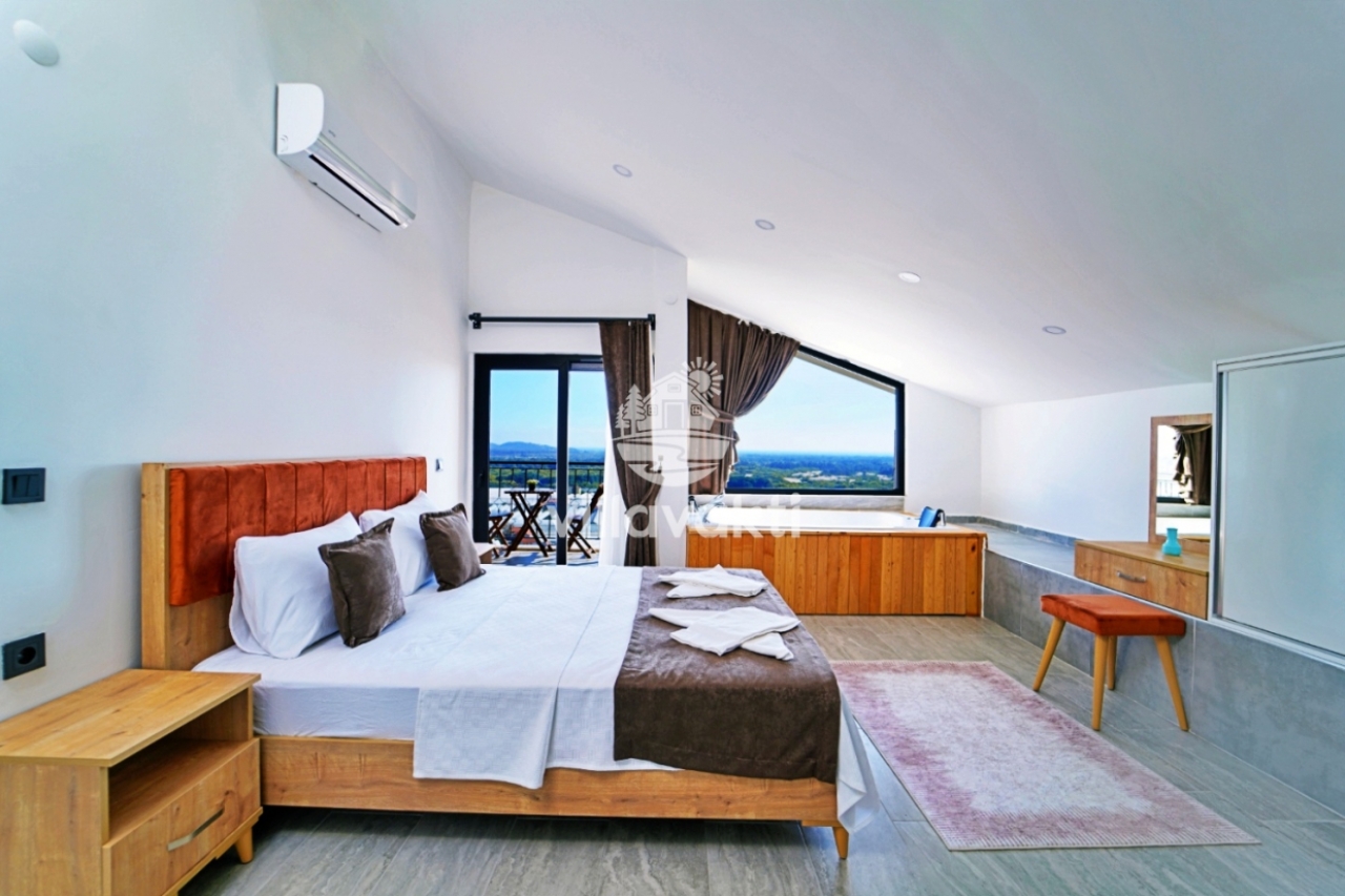 Balkon çıkışlı, jakuzili ve çift kişilik yataklı ferah yatak odası.