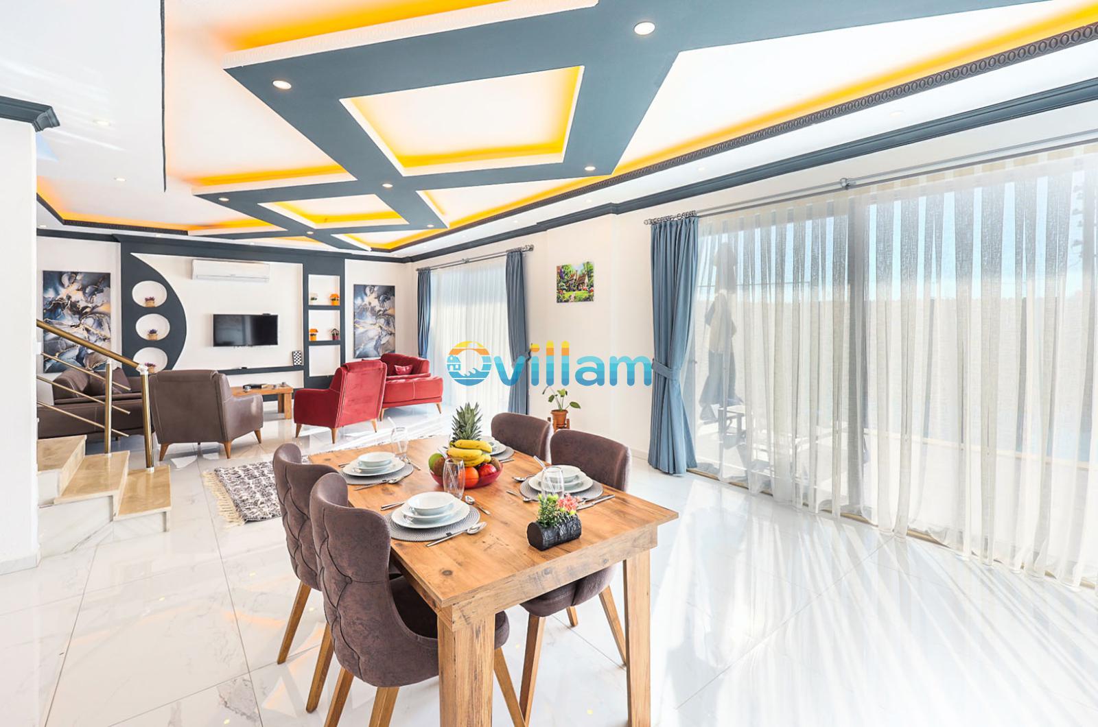 Ahşap yemek masası ve oturma grubu bulunan modern iç mekân.