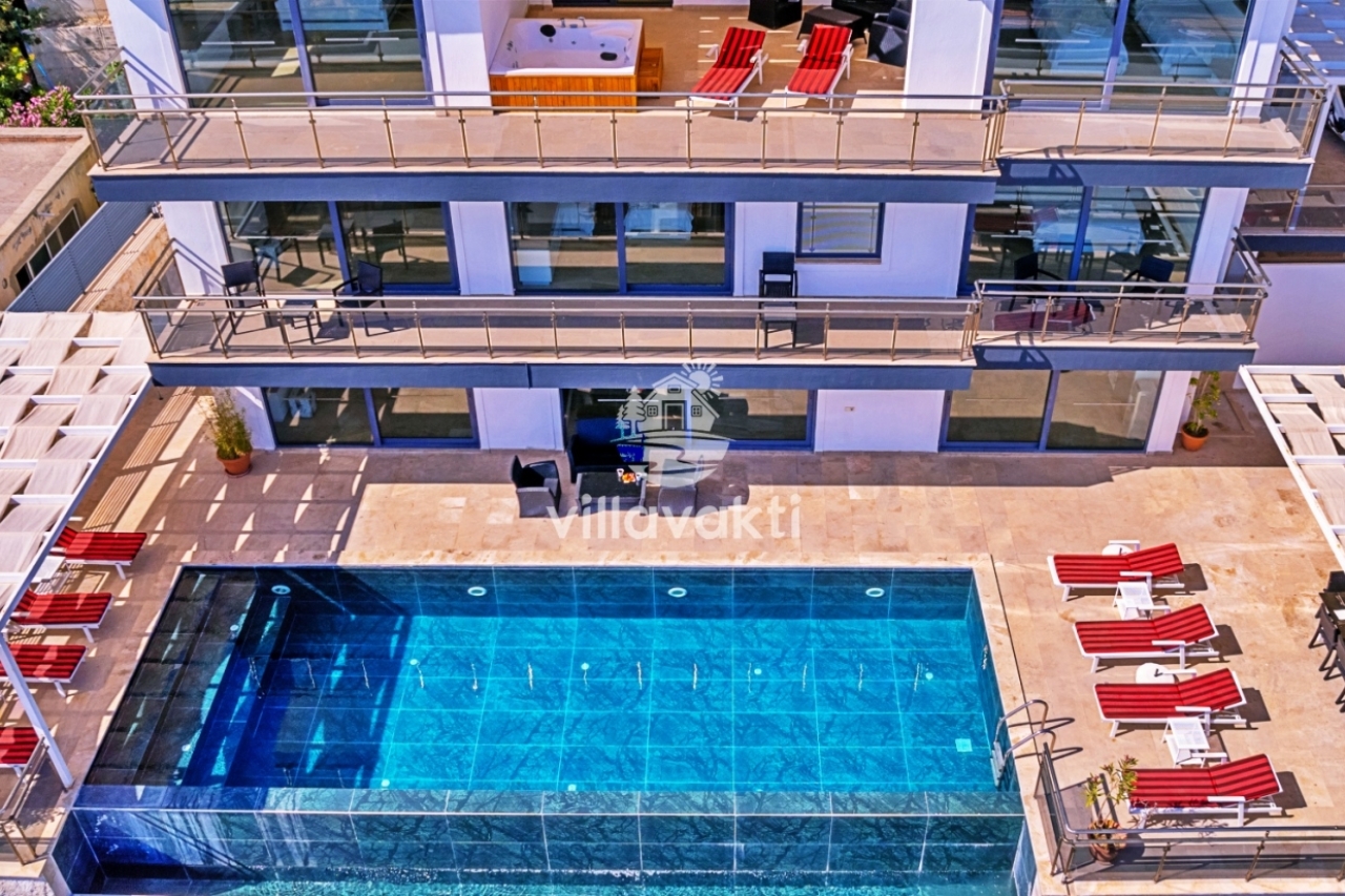 Önünde havuz bulunan modern villanın dış cephesi.