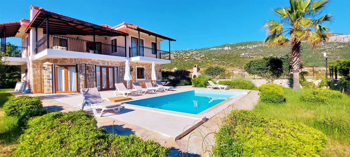 Geniş bahçesi, havuzu ve palmiye ağacı olan iki katlı müstakil villa.