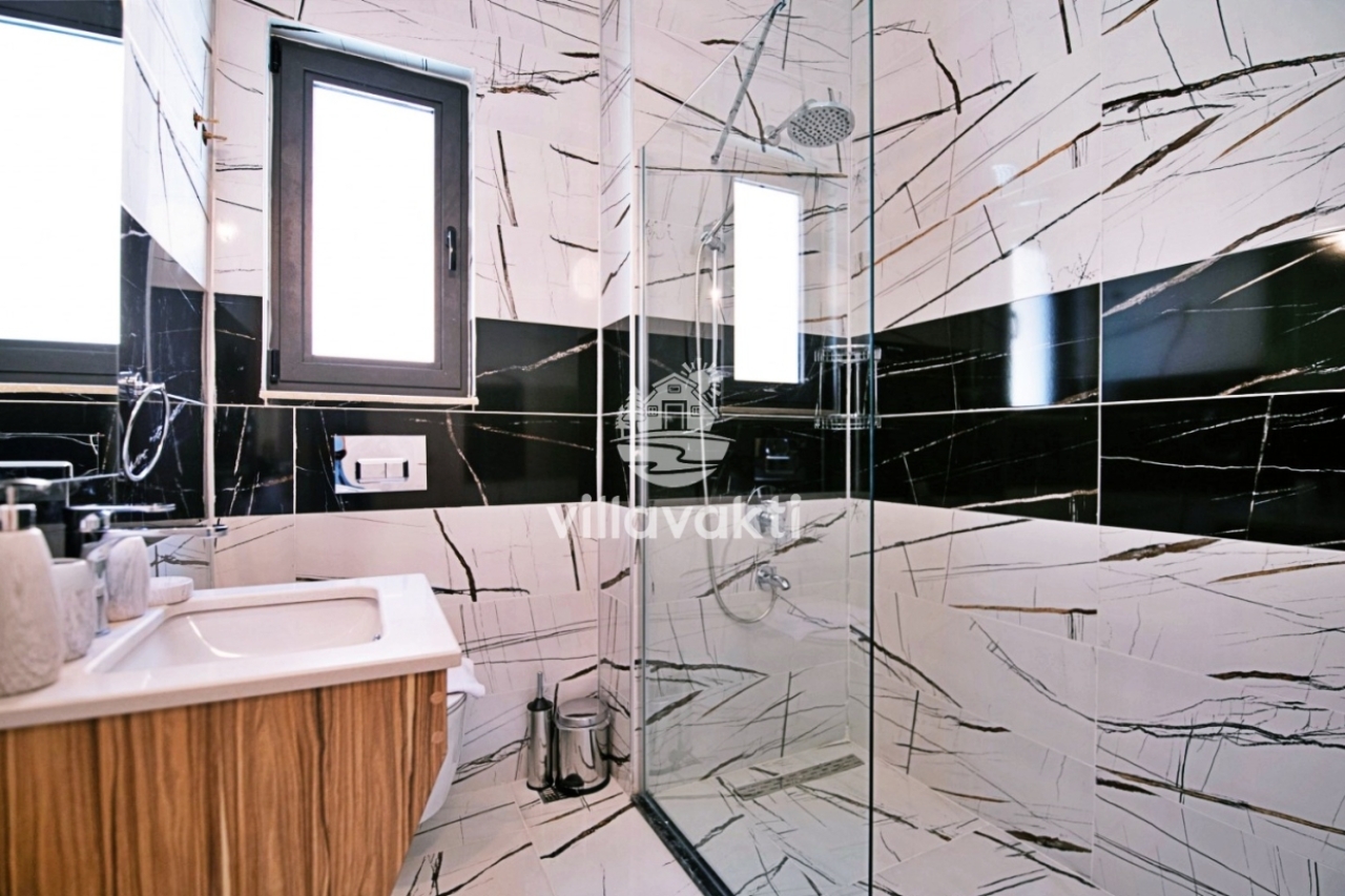 Siyah beyaz mermer detaylı duş alanı ve lavabo.