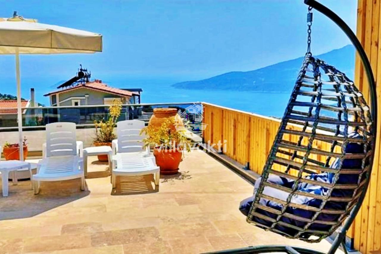 Deniz manzaralı terasta şezlonglar ve salıncak.