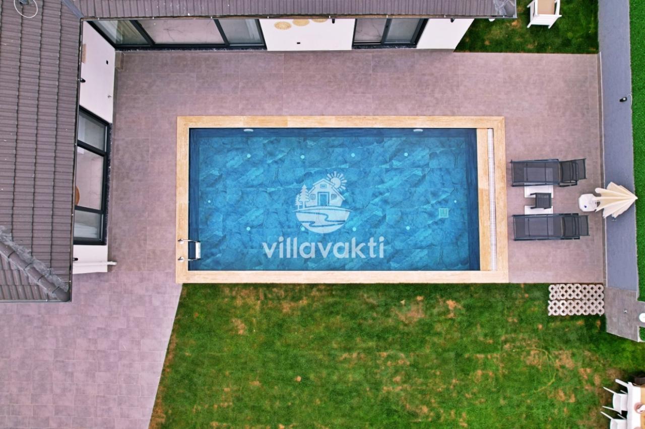 Müstakil villanın dikdörtgen şeklindeki havuzu ve havuz kenarı.